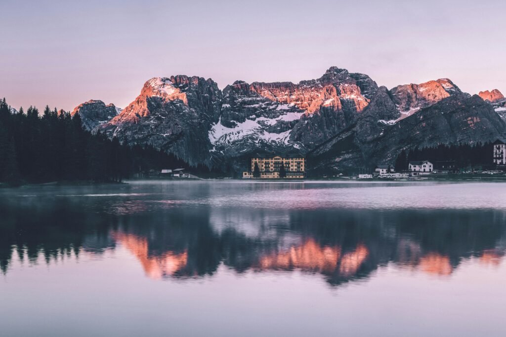 Scenic view of Misurina Lake with mountain reflections at sunrise in Veneto, Italy.